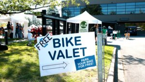 A sign with an arrow pointing to the right. Text reads "Free Bike Valet. Park your bike for free."